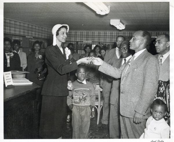 Mrs. Odalie S. Richardson (McDonald), receiving the key to the Carver Branch Library located at 109 ½ Powell’s Alley, Monroe, from B.D. Robinson, representative of the Colored Chamber of Commerce, as his children Carl Dayton and LaSandra watch.