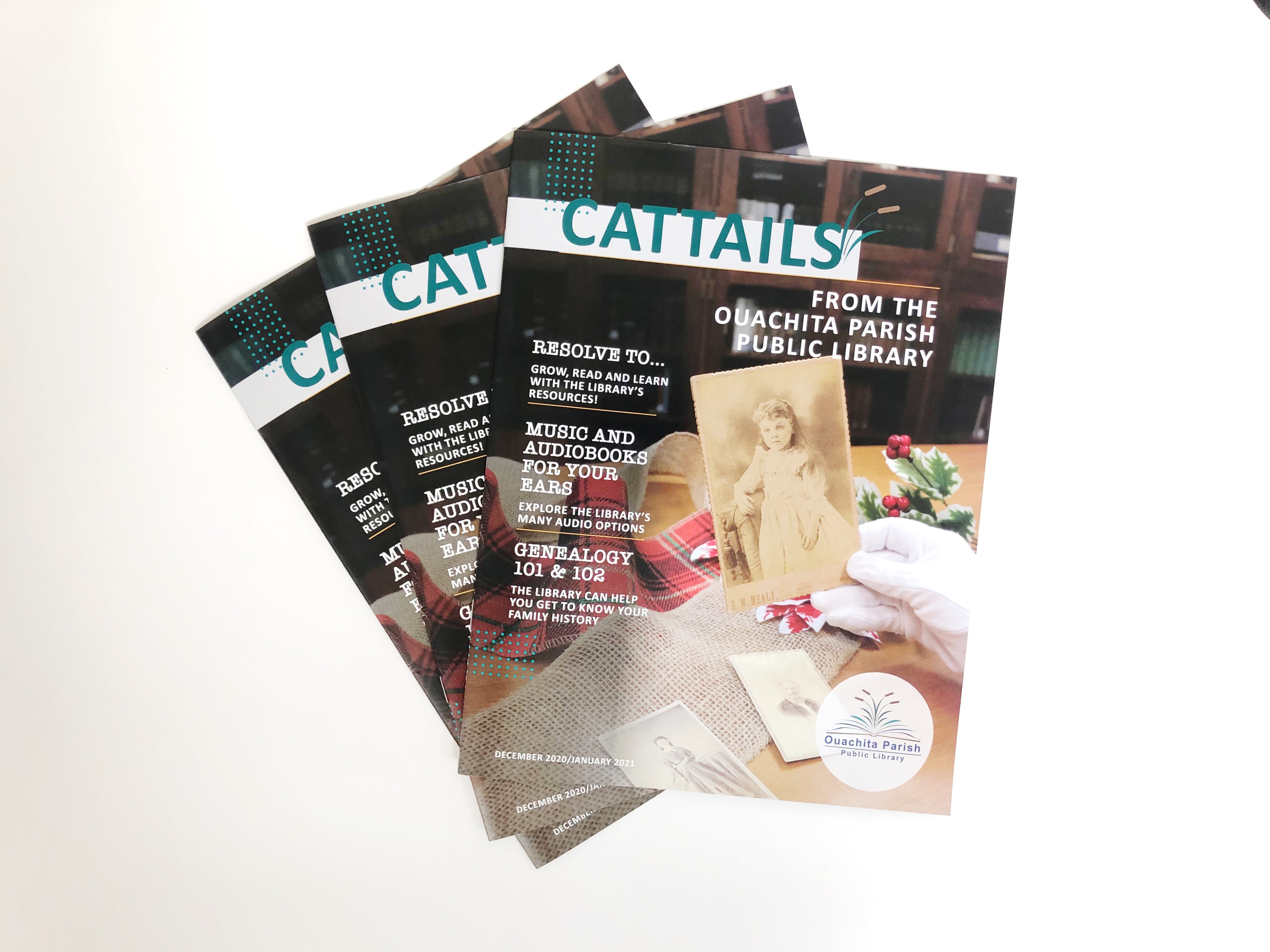 Three issues of the December/January Cattails lay on a white table