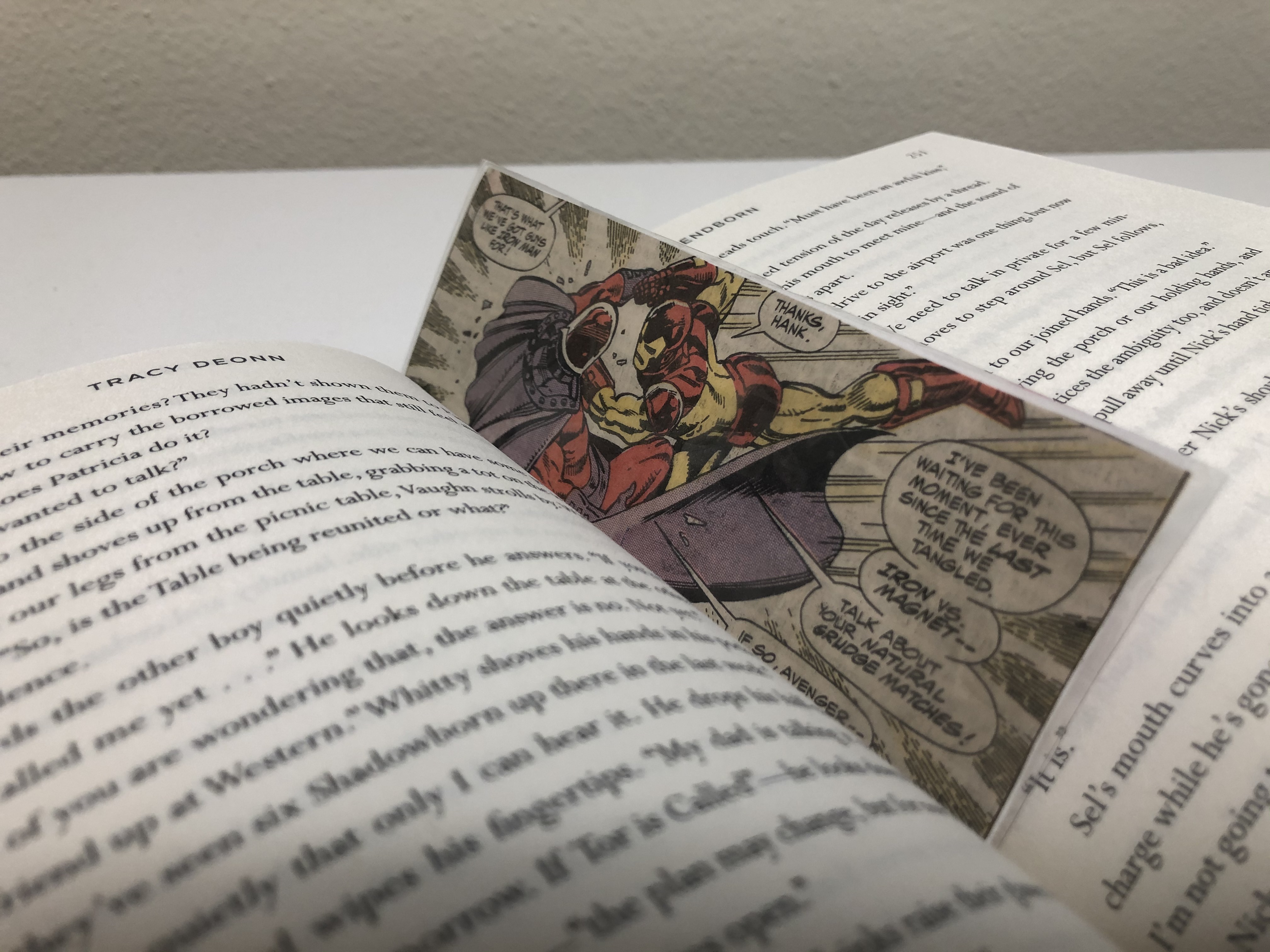 A comic bookmark is in place in the middle of a book.